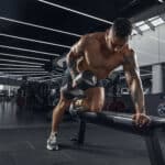 man lifting dumbbells on bench