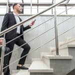 businessman walking up stairs with suitcase