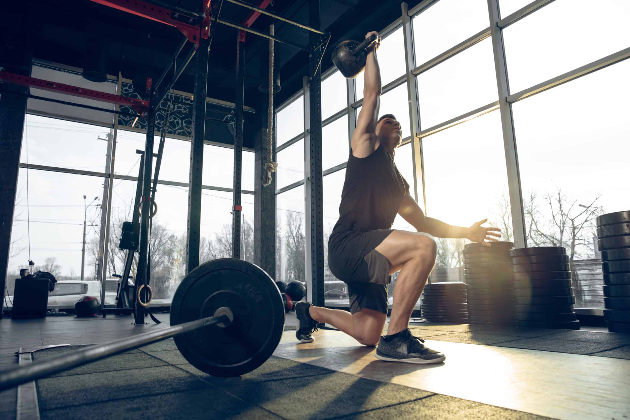 man stretching next to barbell